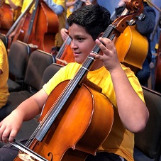 Male student plays cello during concert