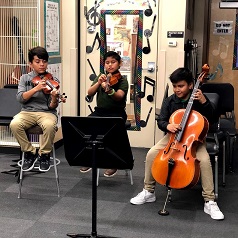 Three students playing a music piece